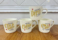 Cream ceramic mugs with vintage-style yellow and black coffee lettering and red accents