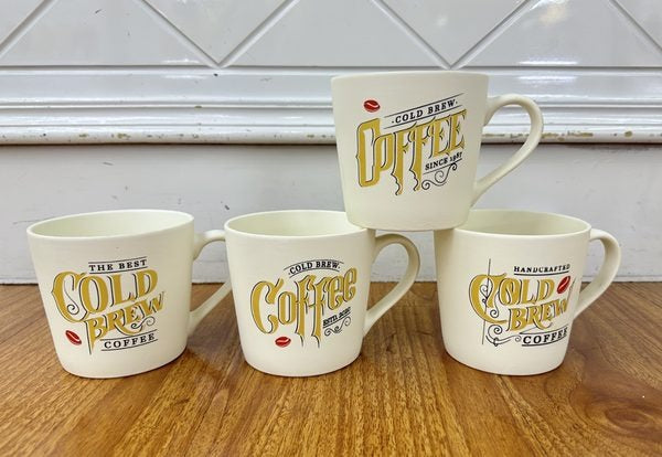 Cream ceramic mugs with vintage-style yellow and black coffee lettering and red accents