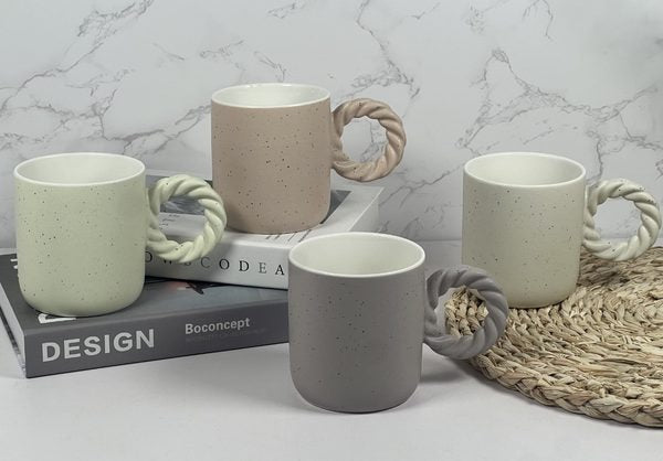 Neutral-toned ceramic mugs with twisted-ring handles and subtle speckling