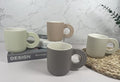 Neutral-toned ceramic mugs with ridged circular handles and subtle speckling