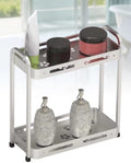 Two-tier square storage rack in a silver finish holding skincare bottles and dispensers on both shelves