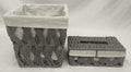 Gray woven paper basket with light fabric liner beside a matching gray woven tissue box holder
